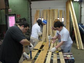 Members work to salvage lumber at the shop